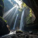 Tukad Cepung Waterfall Bali - Sunlight rays shining through a canyon onto a waterfall
